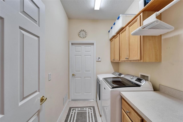 laundry room featuring washing machine and clothes dryer, visible vents, cabinet space, a textured ceiling, and baseboards