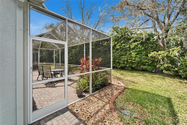 view of yard with glass enclosure and a patio area