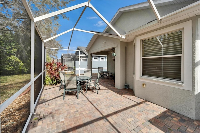 view of patio with glass enclosure and outdoor dining space