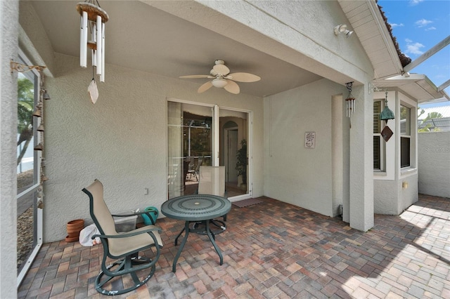 view of patio featuring glass enclosure and ceiling fan