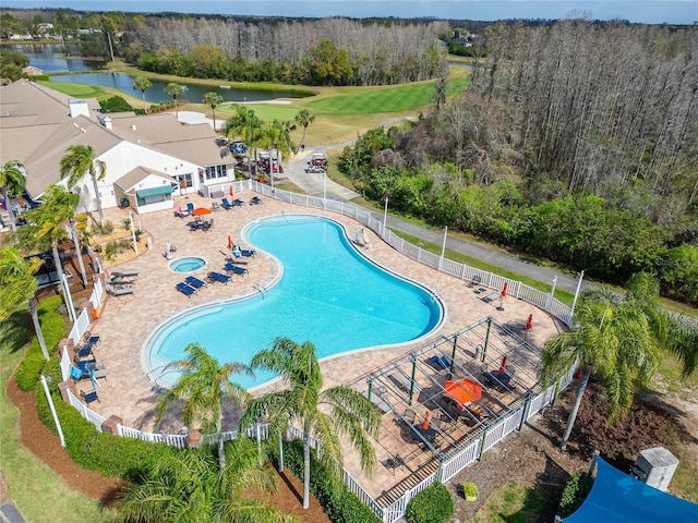 community pool with a water view and fence