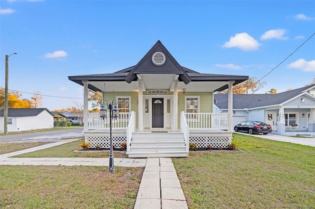 bungalow-style house featuring covered porch and a front lawn