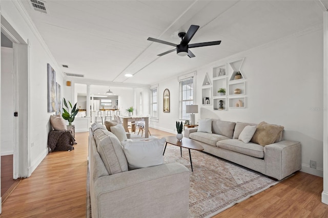 living room featuring visible vents, ceiling fan, light wood-style flooring, and baseboards