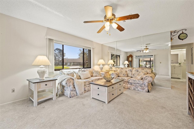 living room with plenty of natural light, a textured ceiling, and light colored carpet