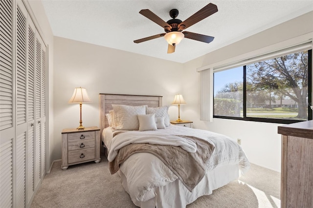 bedroom featuring a closet, carpet flooring, ceiling fan, and a textured ceiling