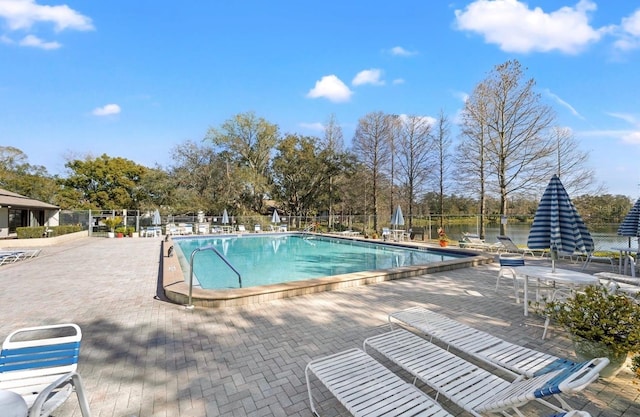 community pool with a patio area and fence