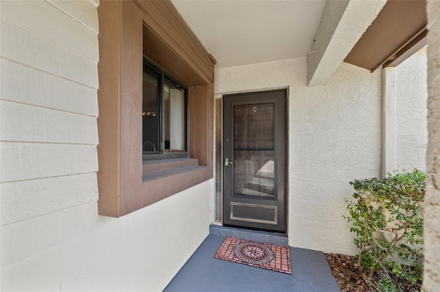 property entrance with stucco siding