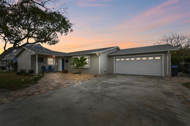 single story home with stucco siding, driveway, and an attached garage