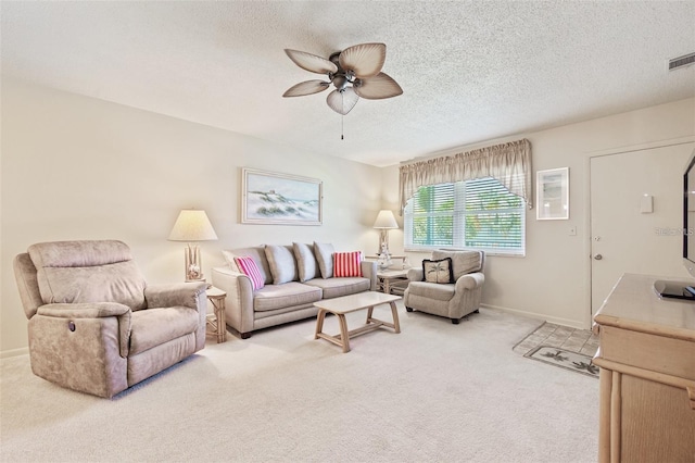 carpeted living room featuring baseboards, visible vents, a ceiling fan, and a textured ceiling