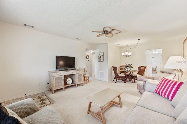 living room with light colored carpet, visible vents, a textured ceiling, and ceiling fan with notable chandelier