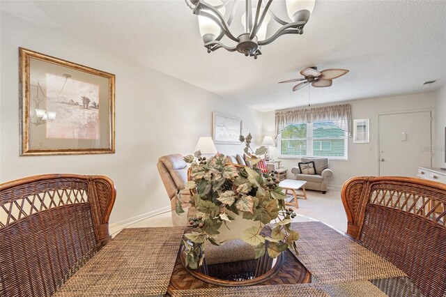 carpeted dining space featuring baseboards, a textured ceiling, visible vents, and a ceiling fan