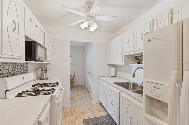 kitchen with tasteful backsplash, white appliances, light countertops, and a sink