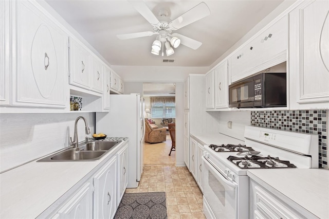 kitchen with black microwave, a sink, visible vents, white cabinets, and white range with gas cooktop