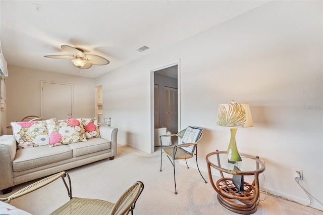 living area featuring baseboards, visible vents, ceiling fan, and carpet flooring