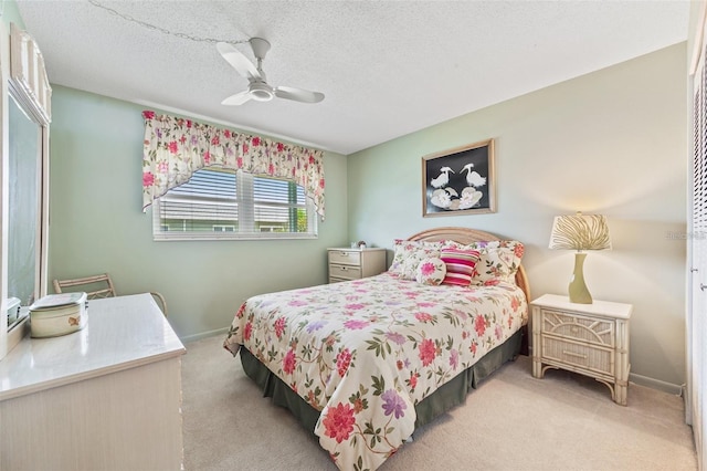 bedroom featuring carpet floors, ceiling fan, a textured ceiling, and baseboards