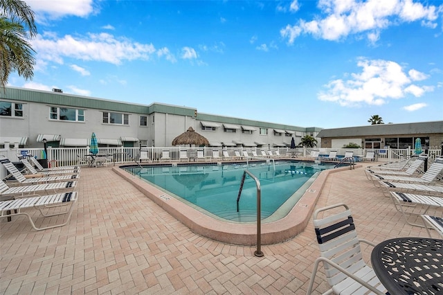 pool with a patio and fence