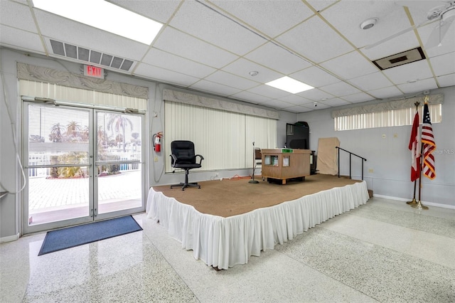 interior space featuring a paneled ceiling, visible vents, and baseboards