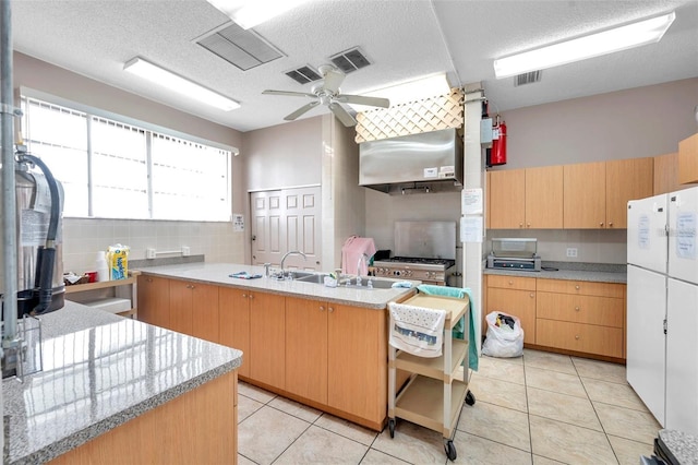 kitchen with visible vents, freestanding refrigerator, a peninsula, light countertops, and backsplash