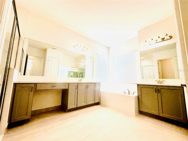 bathroom featuring two vanities, tile patterned flooring, a garden tub, and a sink