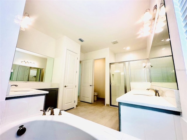 bathroom featuring a stall shower, two vanities, a sink, and visible vents