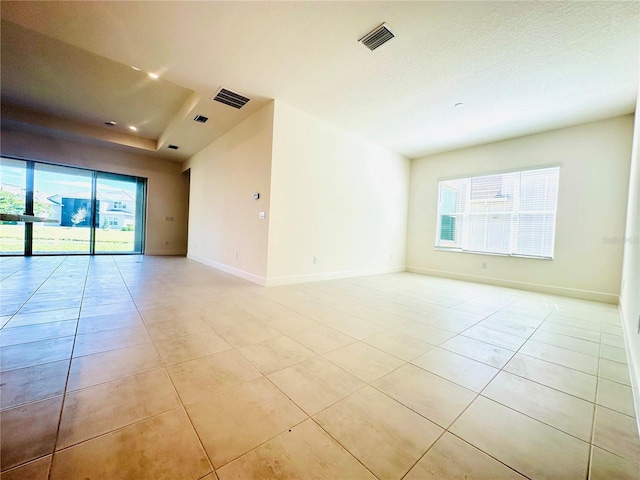 unfurnished room with light tile patterned floors, visible vents, and baseboards