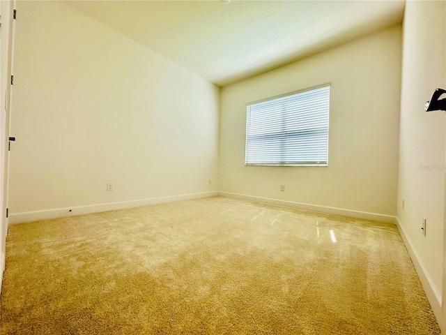 empty room featuring baseboards and light colored carpet