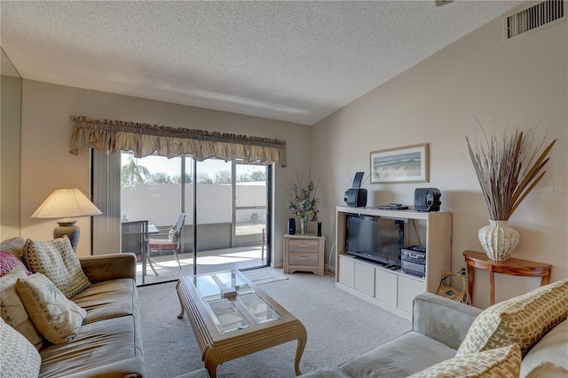 living room featuring lofted ceiling, carpet, visible vents, and a textured ceiling