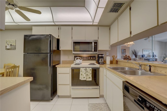 kitchen featuring dishwashing machine, white range with electric cooktop, visible vents, freestanding refrigerator, and stainless steel microwave