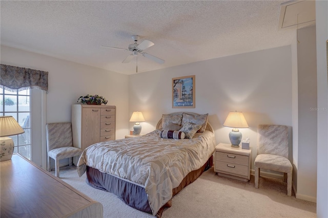 bedroom featuring light carpet, a textured ceiling, and attic access