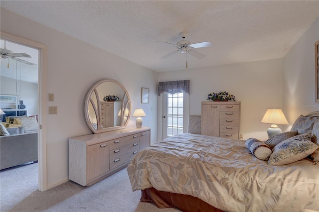 bedroom featuring light carpet, ceiling fan, and a textured ceiling