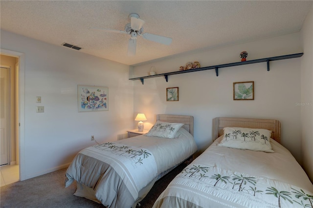 carpeted bedroom with a textured ceiling, visible vents, and a ceiling fan