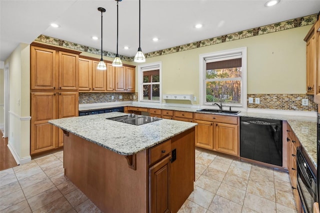 kitchen featuring a sink, black appliances, a kitchen island, and light stone countertops