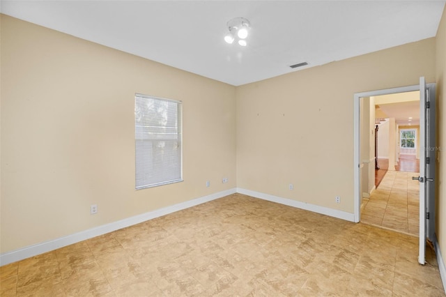 spare room featuring baseboards and visible vents