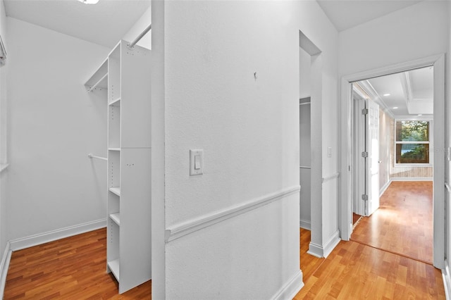 hallway with light wood-type flooring and baseboards