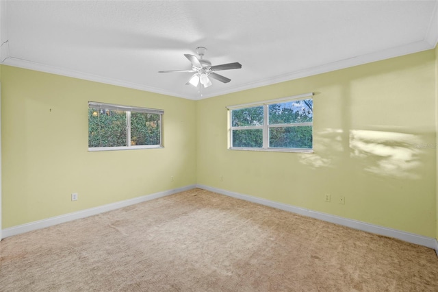 unfurnished room featuring carpet floors, ornamental molding, a ceiling fan, and baseboards