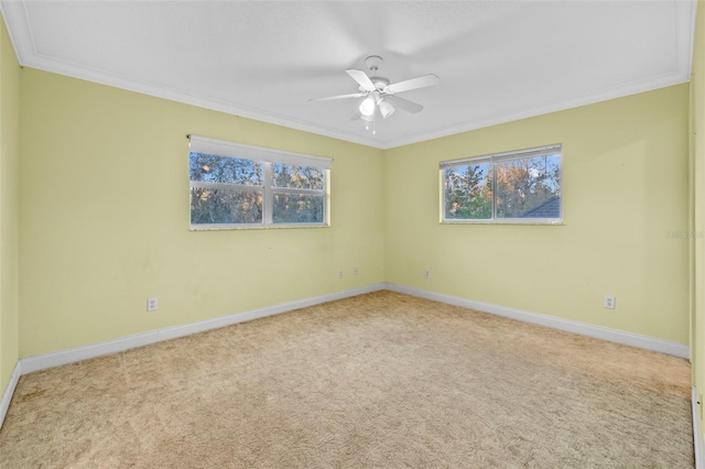 empty room featuring baseboards, carpet floors, ceiling fan, and crown molding