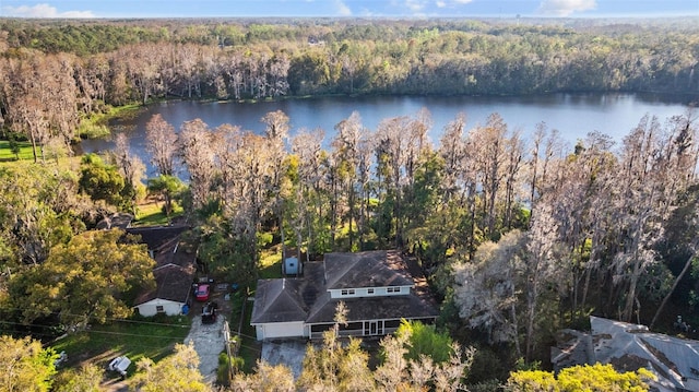 birds eye view of property featuring a forest view and a water view