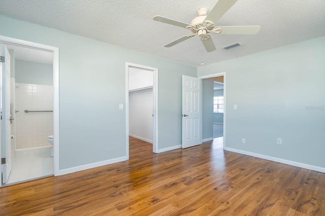 unfurnished bedroom featuring visible vents, a textured ceiling, and wood finished floors