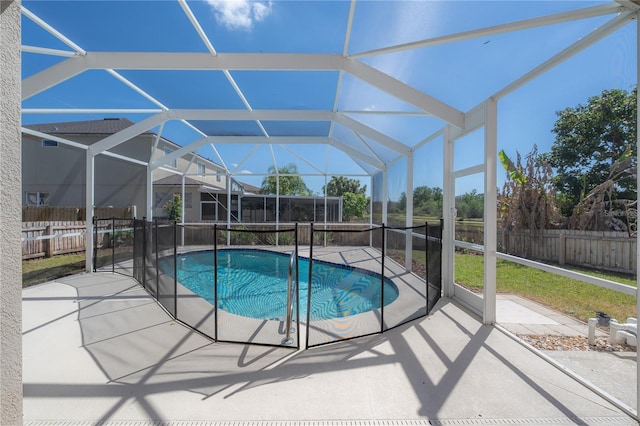 view of pool with glass enclosure, a patio area, and a fenced backyard