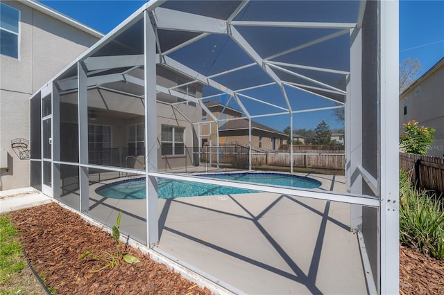 view of swimming pool with glass enclosure, a patio area, a fenced backyard, and a fenced in pool