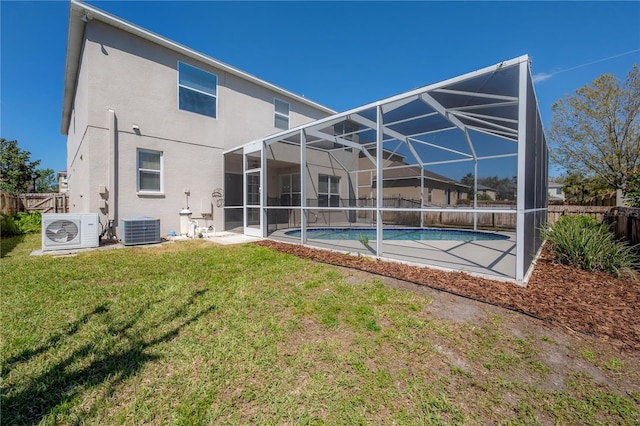 back of property with ac unit, a fenced backyard, central AC unit, and stucco siding