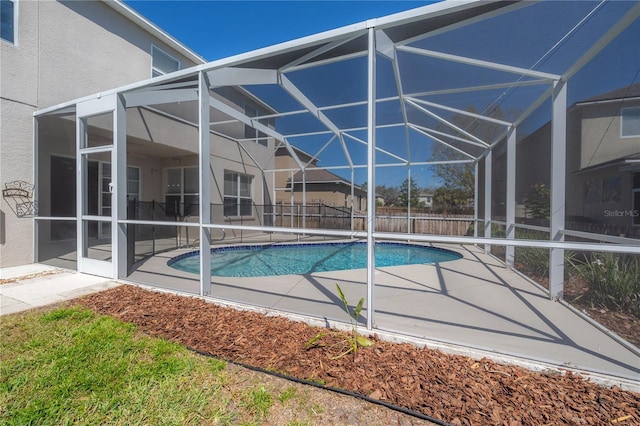 view of swimming pool featuring glass enclosure, fence, a diving board, a fenced in pool, and a patio area