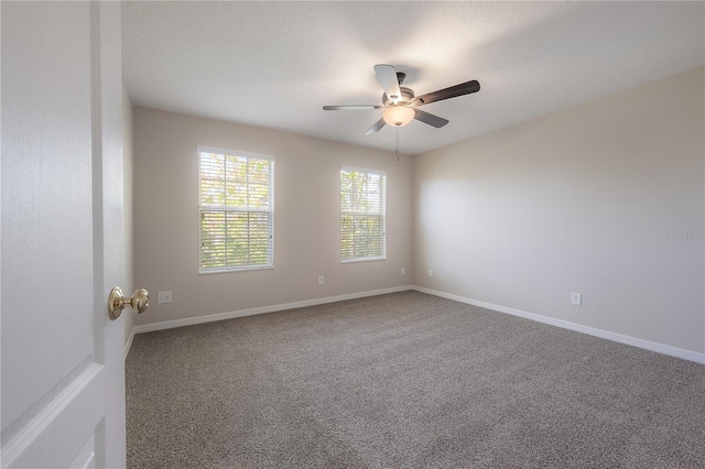 spare room with carpet, baseboards, and a ceiling fan