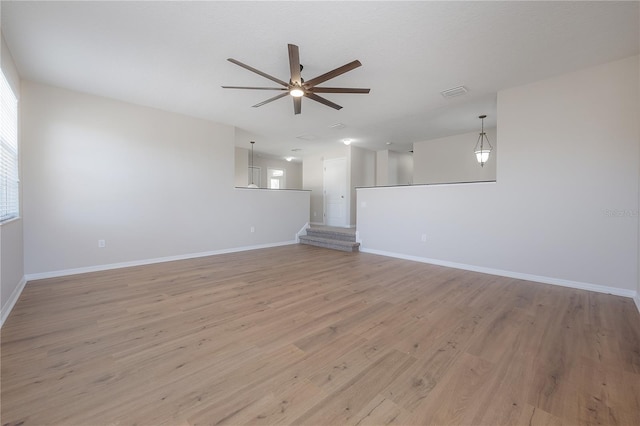 spare room with ceiling fan, light wood-type flooring, and baseboards