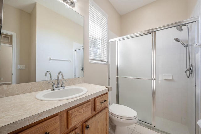 bathroom featuring a stall shower, tile patterned flooring, vanity, and toilet