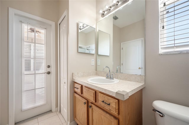 bathroom featuring toilet, vanity, visible vents, and tile patterned floors