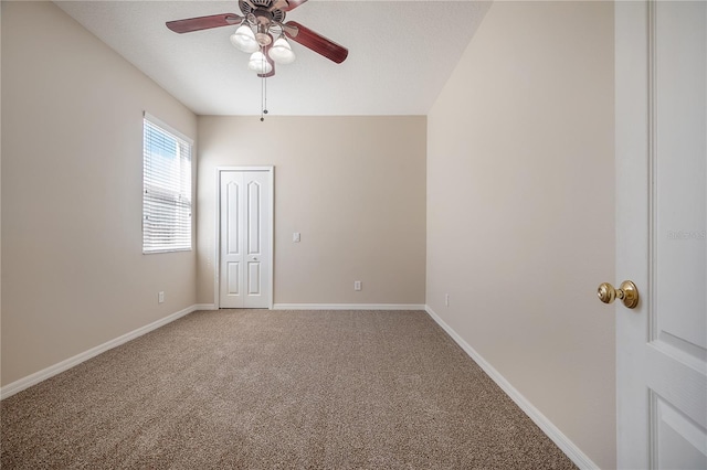 carpeted empty room with ceiling fan and baseboards