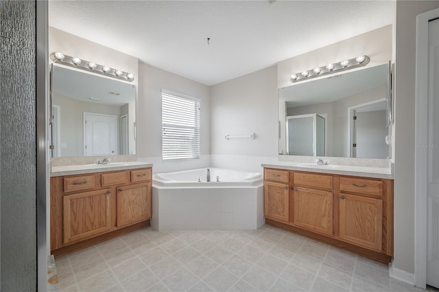 bathroom featuring a sink, two vanities, a garden tub, and a shower stall