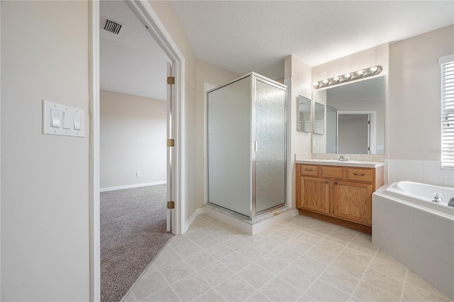 bathroom with a stall shower, visible vents, a garden tub, and vanity