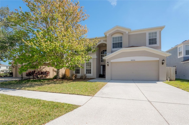 view of front of home with a front yard, driveway, and stucco siding